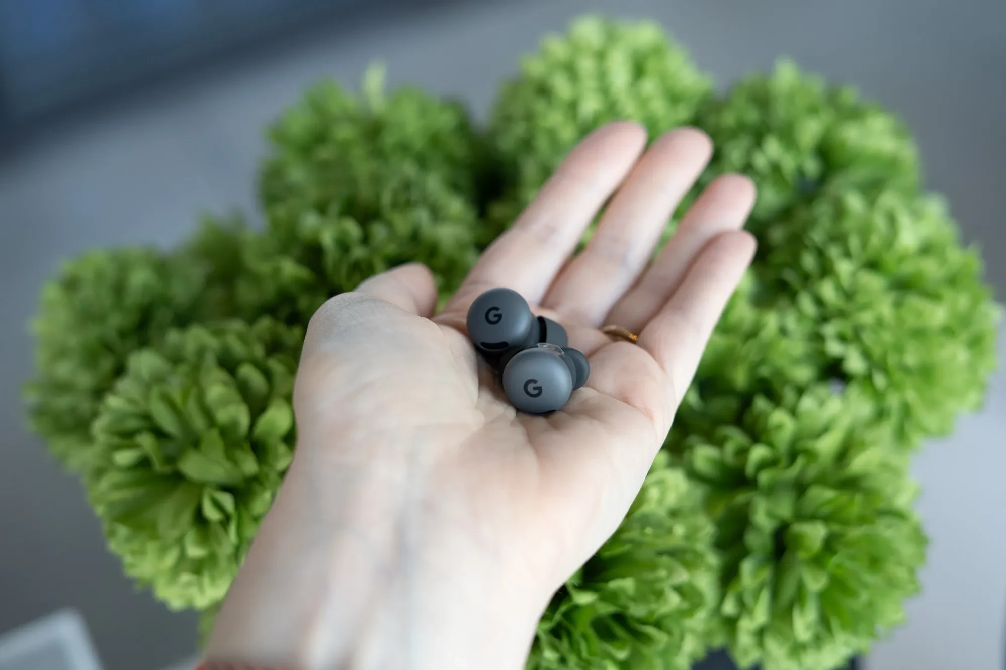 Демонстрация беспроводных наушников Google Pixel Buds 2A в руке